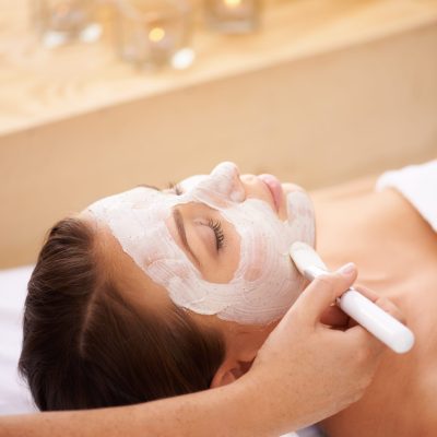 Cream, spa and woman with a face mask, dermatology and treatment for acne, skincare and grooming. Female person, model and girl with a brush, creme and organic facial with wellness, beauty and health.